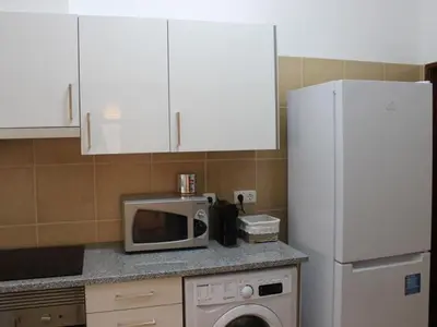 a kitchen with a microwave and a refrigerator at Albufeira Apartments in Albufeira