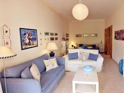 a living room with a blue couch and a white couch at Los Arcos Apartment I in Vilamoura