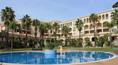 a large building with a large pool in front of it at Los Arcos Apartment I in Vilamoura