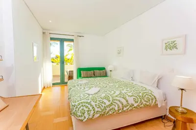 a bedroom with a bed with a green and white bedspread at Marina Vilamoura - Aquamar 003 By Vilamoura Sun in Vilamoura
