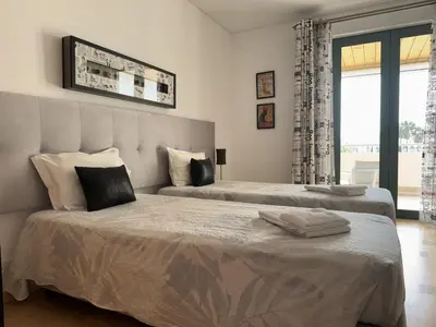 a bedroom with two beds and a large window at Marina Vilamoura - Aquamar 209 - By Vilamoura Sun in Vilamoura