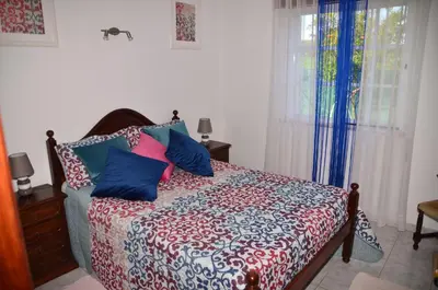 a bedroom with a bed with colorful pillows on it at Villa Batista in Guia