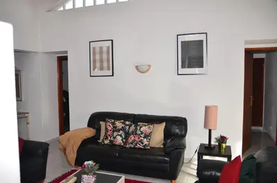 a living room with a black leather couch at Villa Batista in Guia