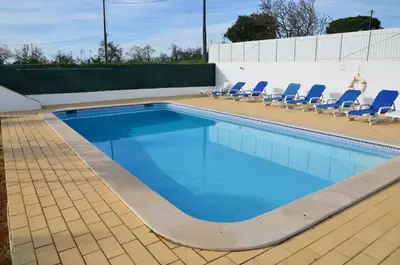 a swimming pool with blue chairs and a swimming pool at Villa Batista in Guia