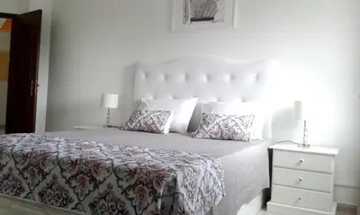 a white bedroom with a large bed and a nightstand at Elegant Villa in Albufeira with Private Pool. in Albufeira