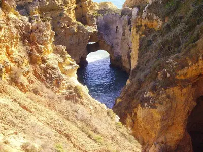 a cave in a rocky mountain with a body of water at Elegant Villa in Albufeira with Private Pool. in Albufeira