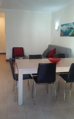 a room with a table and chairs and a couch at Salgados Village T1 in Albufeira
