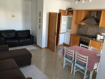 a kitchen and living room with a table and chairs at Excelente T1 Oura Beach Bicos Apartment Lucia in Albufeira