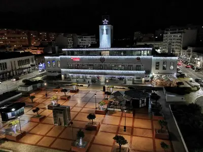 a large building with a clock tower at night at The Market Square House in Faro