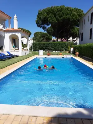two people swimming in a swimming pool in a house at Casa Sol da Falesia in Albufeira