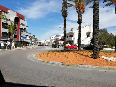 a large white building on the side of a street at Albufeira INN - CORAL T1 in Albufeira