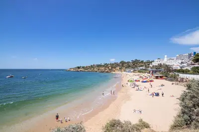 a group of people on a beach with the ocean at Beti Oura Village in Albufeira