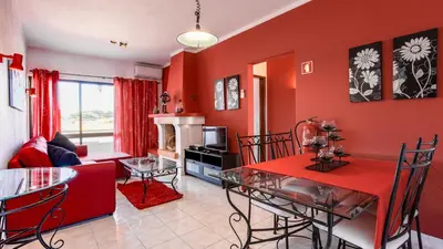 a living room with red walls and a red dining room at ★ Sea View ★ 1 Minute to Oldtown and Beach ★ in Albufeira