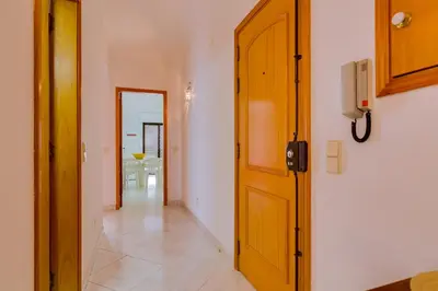 a hallway with a wooden door and a dining room at Atlântico View - Beach front - Quarteira in Quarteira