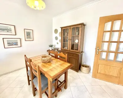 a dining room with a wooden table and chairs at Atlântico View - Beach front - Quarteira in Quarteira