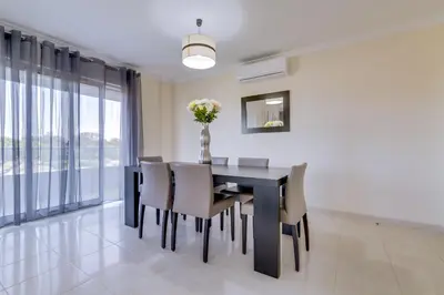 a dining room with a black table and chairs at Forte Novo - Modern apartment - Quarteira in Quarteira