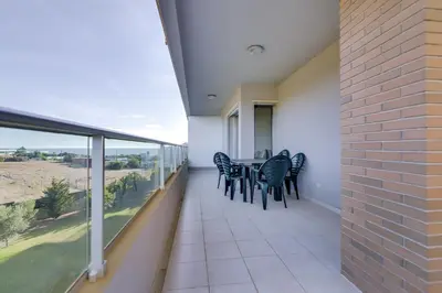 a balcony with black chairs and a table on it at Forte Novo - Modern apartment - Quarteira in Quarteira