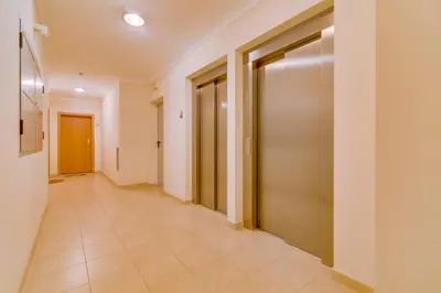 a corridor of a building with doors and tile floors at Forte Novo - Modern apartment - Quarteira in Quarteira
