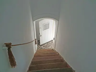 a stairway with a white door and a white hallway at Old Charming House Faro in Faro