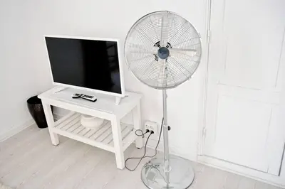 a white room with a white fan next to a tv at Old Charming House Faro in Faro