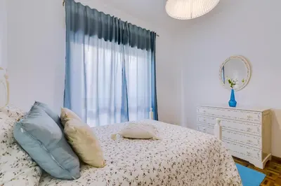a bedroom with a bed with pillows and a window at Casa da Esquina - Faro city center in Faro