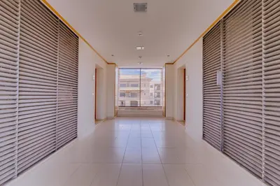 an empty hallway with large windows and wooden shutters at Amazing 2Bedroom apartment in Victoria Boulevard in Vilamoura