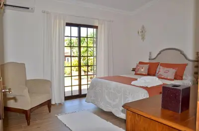 a living room with two chairs and a fireplace at Fantastic for Family Gatherings, Optional Pool Heating, Free Air Con Wifi in Quarteira