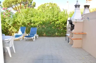 a swimming pool with chairs and a house at Stylish and well-equipped, private pool, close to amenities, free AC and Wifi in Quarteira