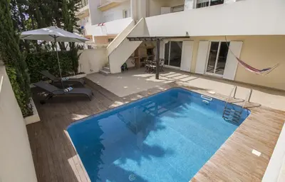 a hammock in a room with a swimming pool at Casa Oliveira in Loulé