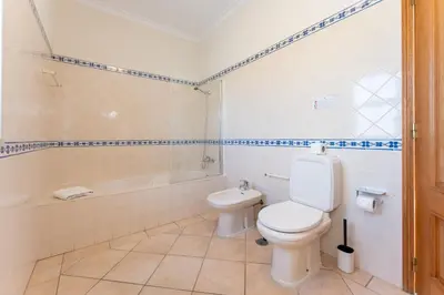 a bathroom with a toilet and a bath tub at Quinta das Laranjeiras in Boliqueime