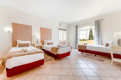 a hotel room with two beds and a window at Quinta das Laranjeiras in Boliqueime