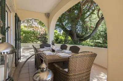 a patio with a table and chairs on a porch at Villa Caravela in Almancil