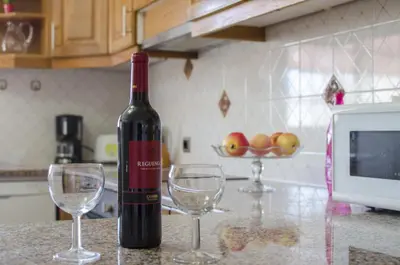 a bottle of wine sitting on a counter with two wine glasses at Villa Magali in Galé