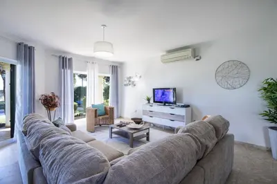 a living room with a couch and a tv at Casa Clara in Vilamoura