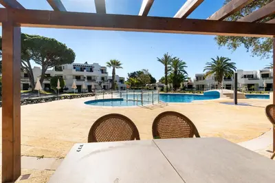 a swimming pool with a stone wall around it at Apartments Maria - Balaia 702 in Albufeira