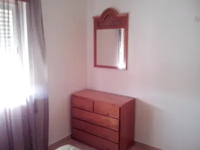 a bedroom with a dresser and a mirror on the wall at Charming Apartment in Albufeira with Shared Pool in Albufeira