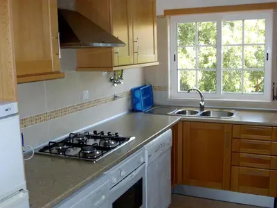 a kitchen with a stove top oven next to a sink at Charming Apartment in Albufeira with Shared Pool in Albufeira