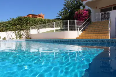 a swimming pool in front of a house with stairs at Vivenda ROSA Albufeira in Fontainhas