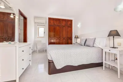 a white bedroom with a bed and a sink at Villa Chiquito Albufeira - Private Pool&Parking - BBQ&AC&WI-FI in Albufeira