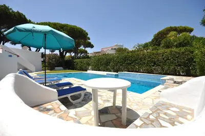 a dining room and kitchen with a table and chairs at Delightful single-storey villa, private pool, free air conditioning and wifi in Vilamoura