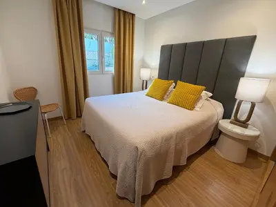 a bedroom with a large bed with yellow pillows at Pine Tree Seaside Apartments 500m to Beach in Albufeira