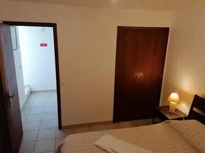 a bedroom with a bed and a closet and a door at Oceana in Faro