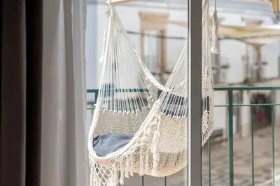 a hammock hanging on a balcony next to a window at Downtown Lux Apartment in Faro