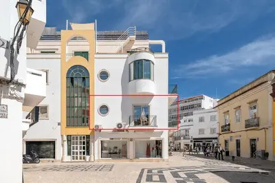 a white building with yellow accents on a city street at Downtown Lux Apartment in Faro