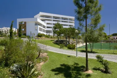 a building with a tennis court in a park at Alfagar Aparthotel in Albufeira