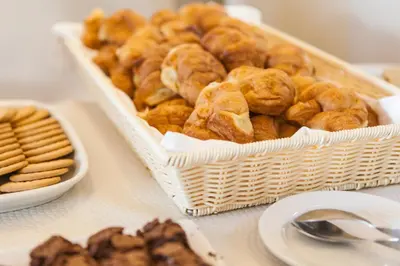 a table topped with a basket of pastries and cookies at Alfagar Aparthotel in Albufeira