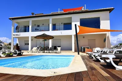 a villa with a swimming pool in front of a house at Villa Bellevue in Albufeira