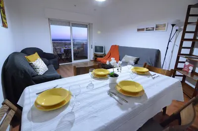 a living room with a white table with yellow plates on it at Wonderful view in the city center in Faro