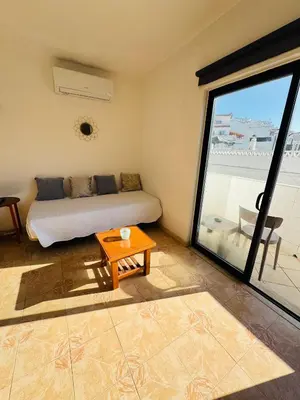 a bedroom with a bed and a table and a window at Apartment old town MFA in Albufeira
