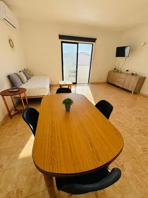 a wooden table and chairs in a room with a bed at Apartment old town MFA in Albufeira